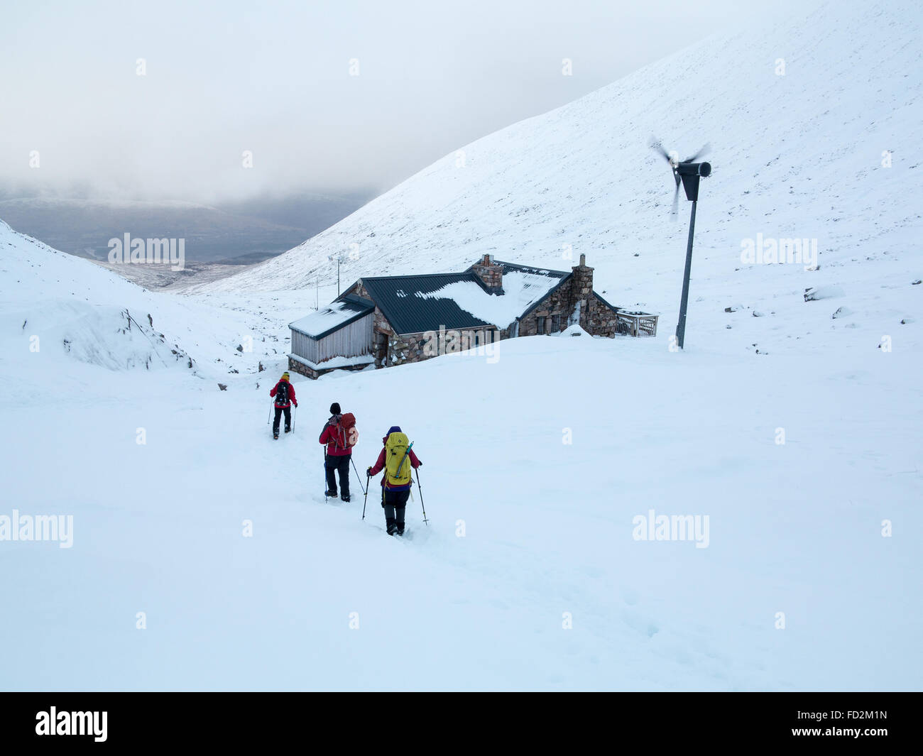 Mountaineers walk past the CIC mountaineering hut below the North Face of Ben Nevis near Fort William in the Scottish Highlands Stock Photo