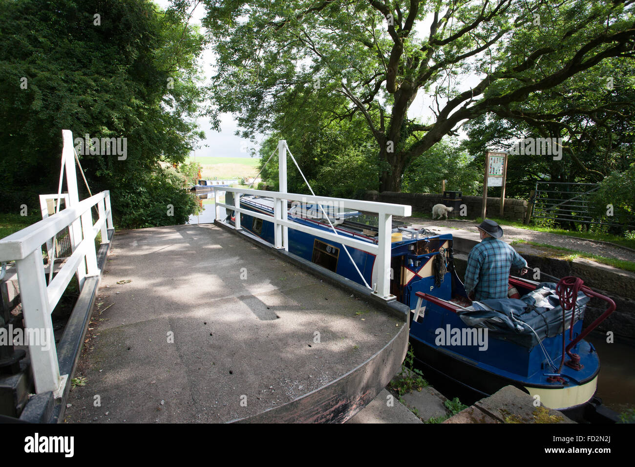 Narrow Boat Passing Past An Open Swing Bridge Stock Photo