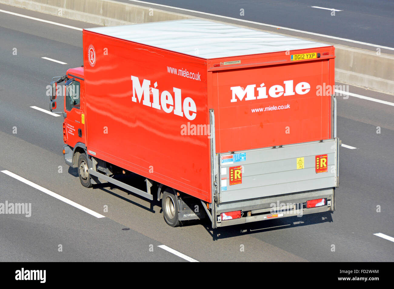 Side & back view German business & manufacturer of domestic appliances Miele  lorry truck with tailgate platform hoist driving on motorway England UK  Stock Photo - Alamy