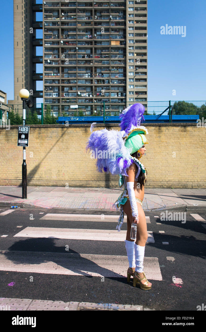 Dancer from Paraiso School of Samba waiting to join parade route with Trellick Tower in backgroud, Notting Hill Carnival 2013 Stock Photo