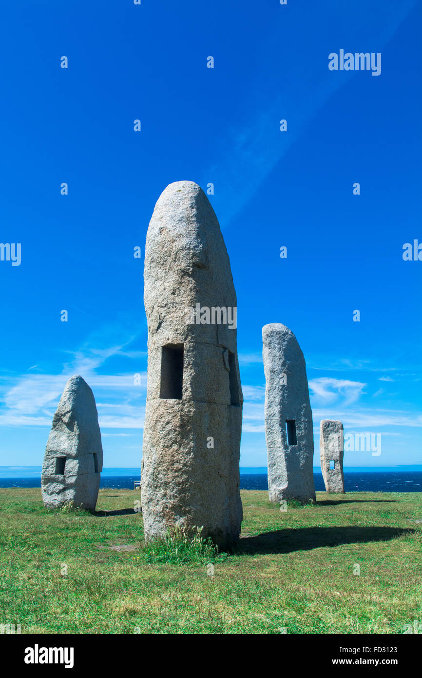 Ancient Monuments With Holes In Green Field Against Clear Blue Sky Stock Photo