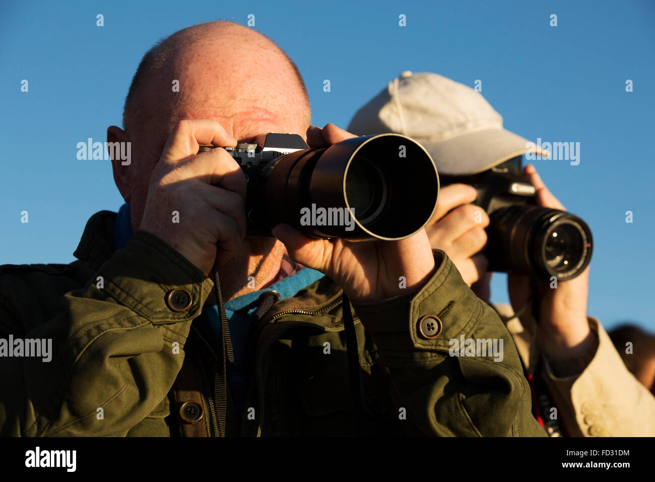 Travel photographers on Mount Teide in Teide National Park on Tenerife, Spain. They photograph a nearby scene. Stock Photo