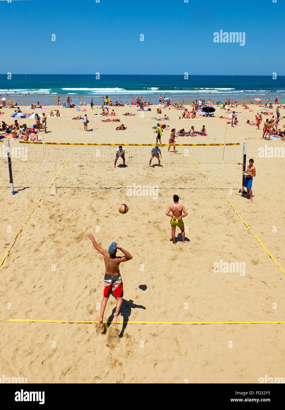 Youngs mens playing volleyball in the Zurriola beach, San Sebastian