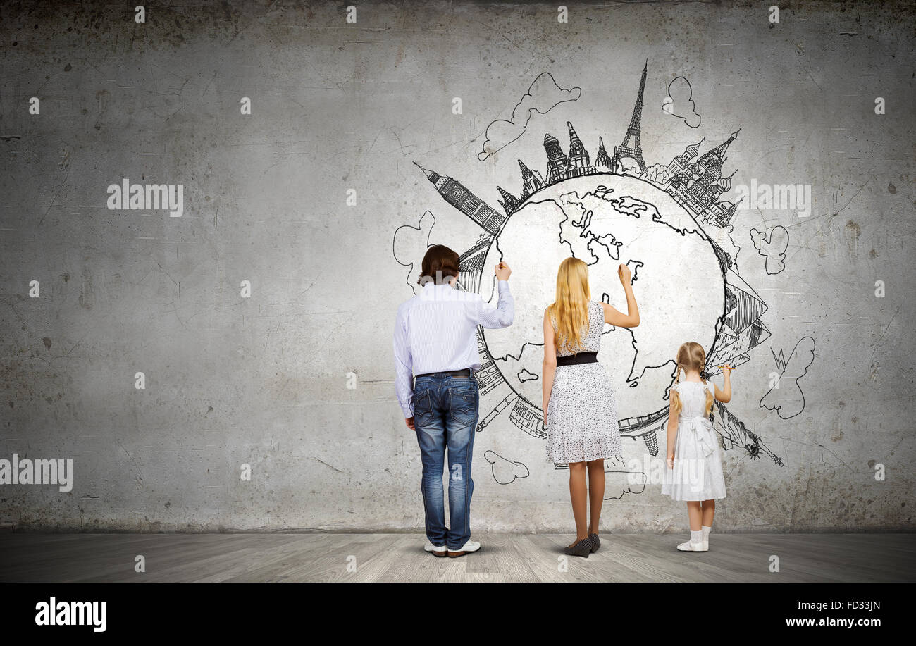 Rear view of family drawing Earth planet on wall Stock Photo