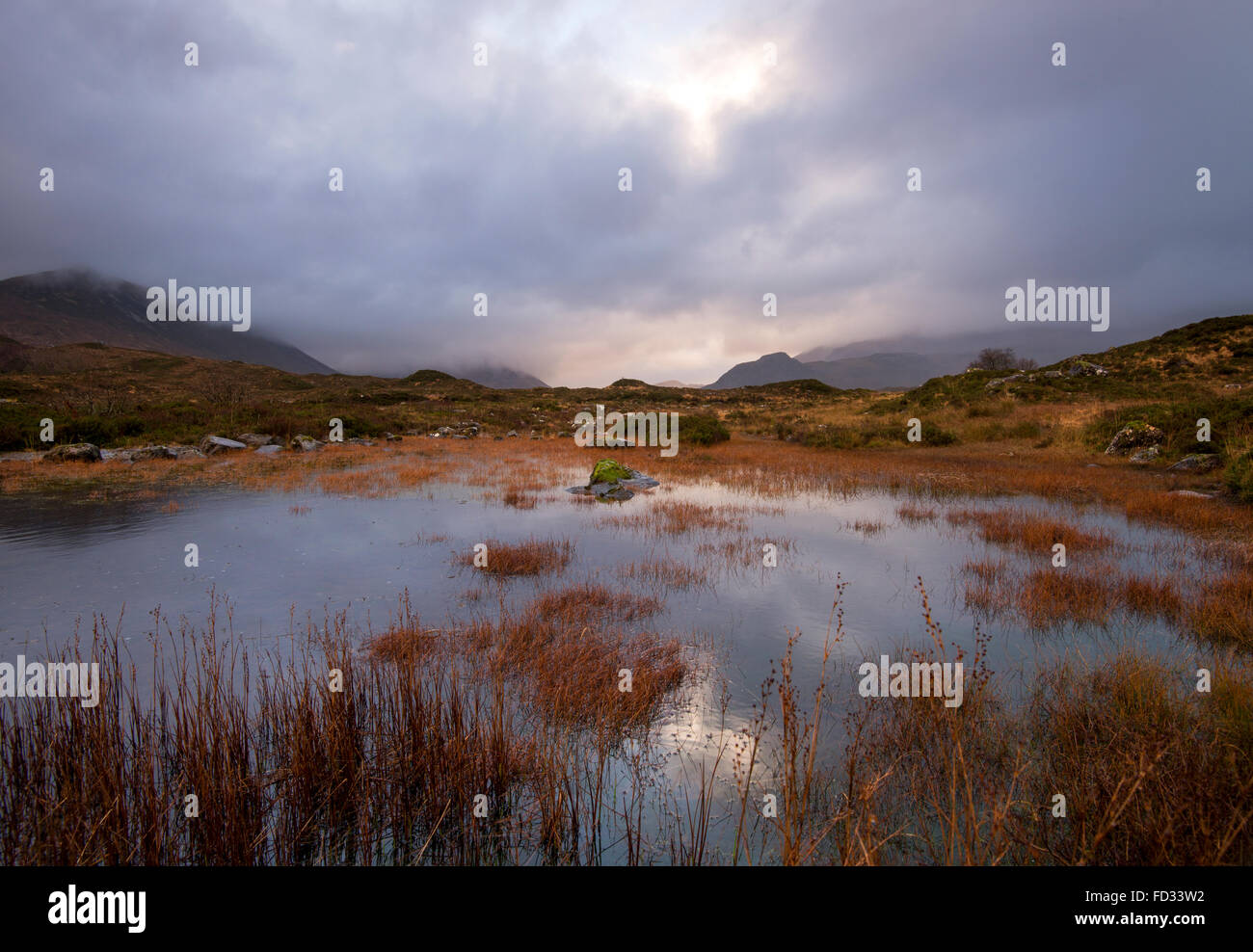 Dramatic Light reflected in a small Lochan at Sligachan, Isle of Skye Scotland UK Stock Photo