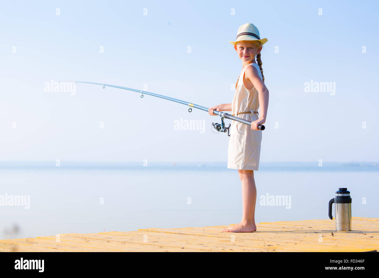 https://c8.alamy.com/comp/FD346F/girl-in-a-dress-and-a-hat-with-a-fishing-rod-fishing-from-the-pier-FD346F.jpg