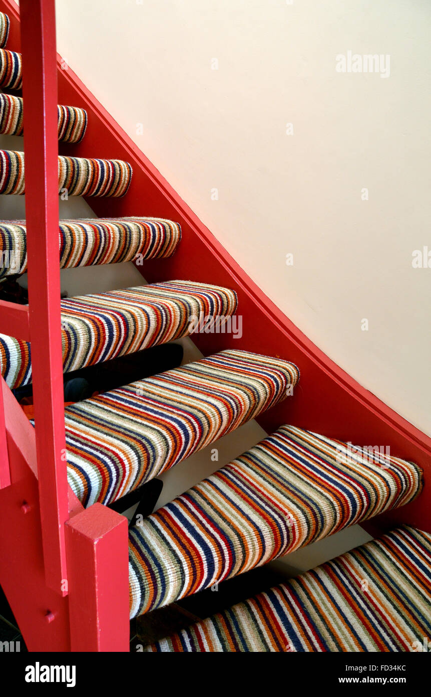 A section of a  stripey carpeted simple staircase. Stock Photo