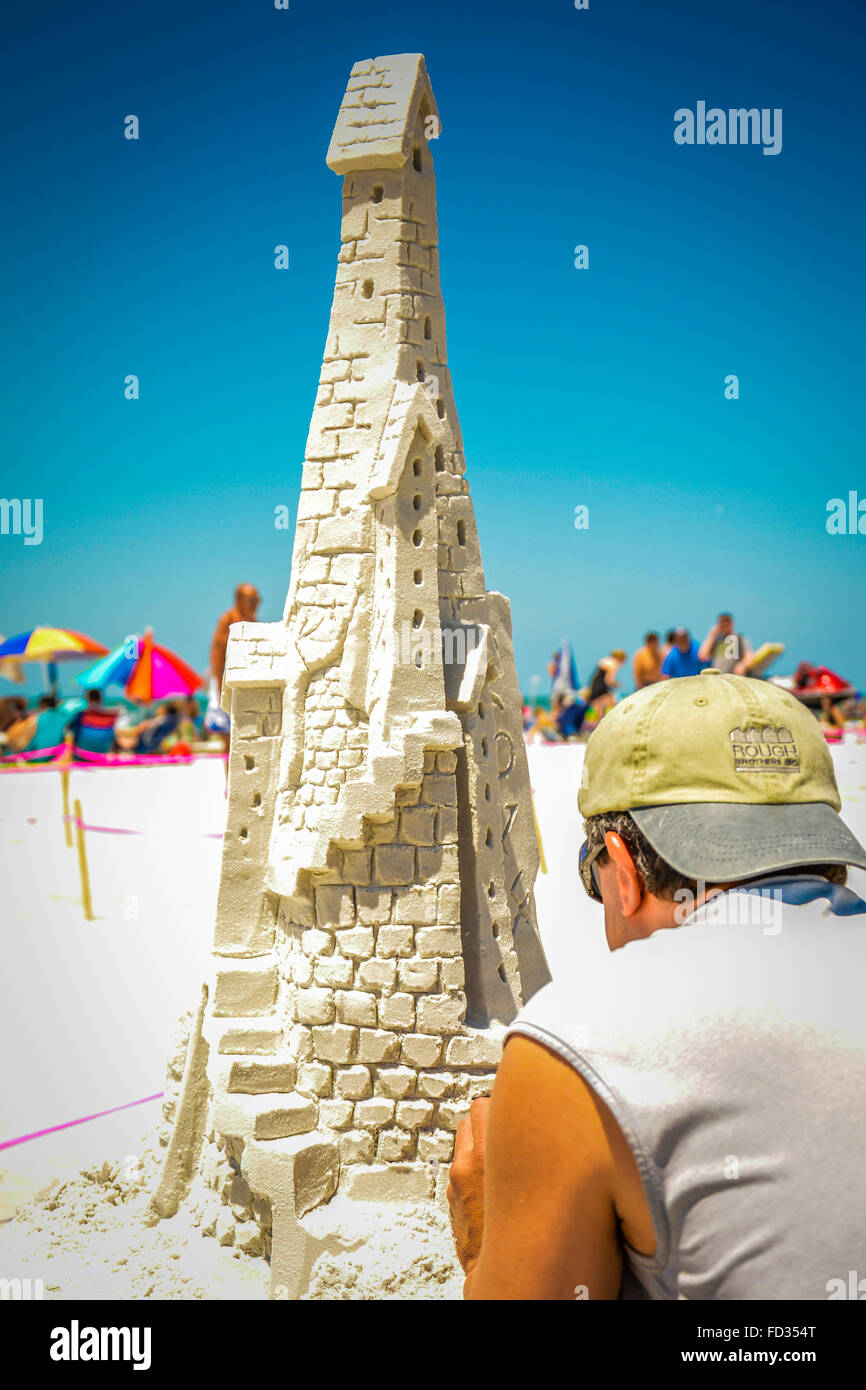 A man works on an elaborate sandcastle construction during a competition at Siesta Key Beach, FL Stock Photo