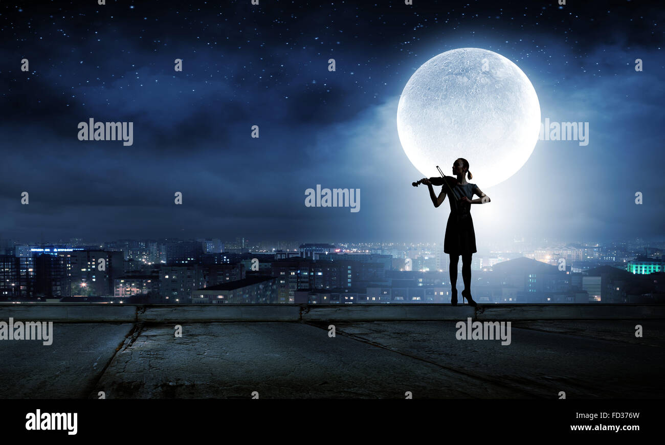 Silhouette of woman playing violin at night Stock Photo - Alamy