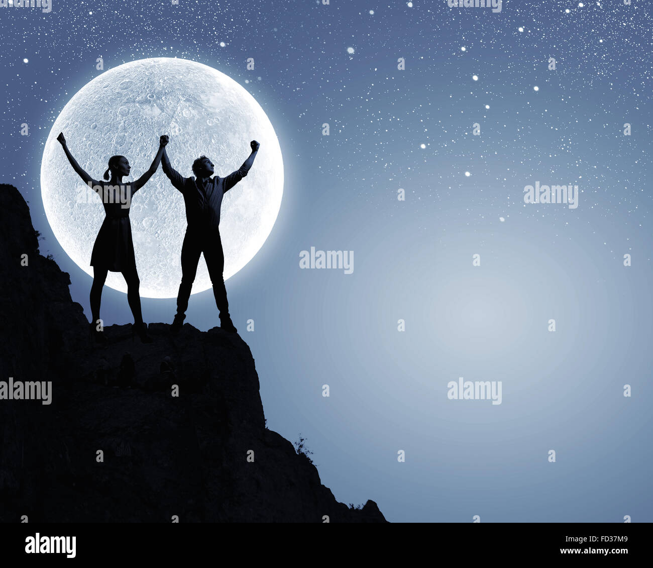 Silhouettes of young romantic couple standing under the moon light ...