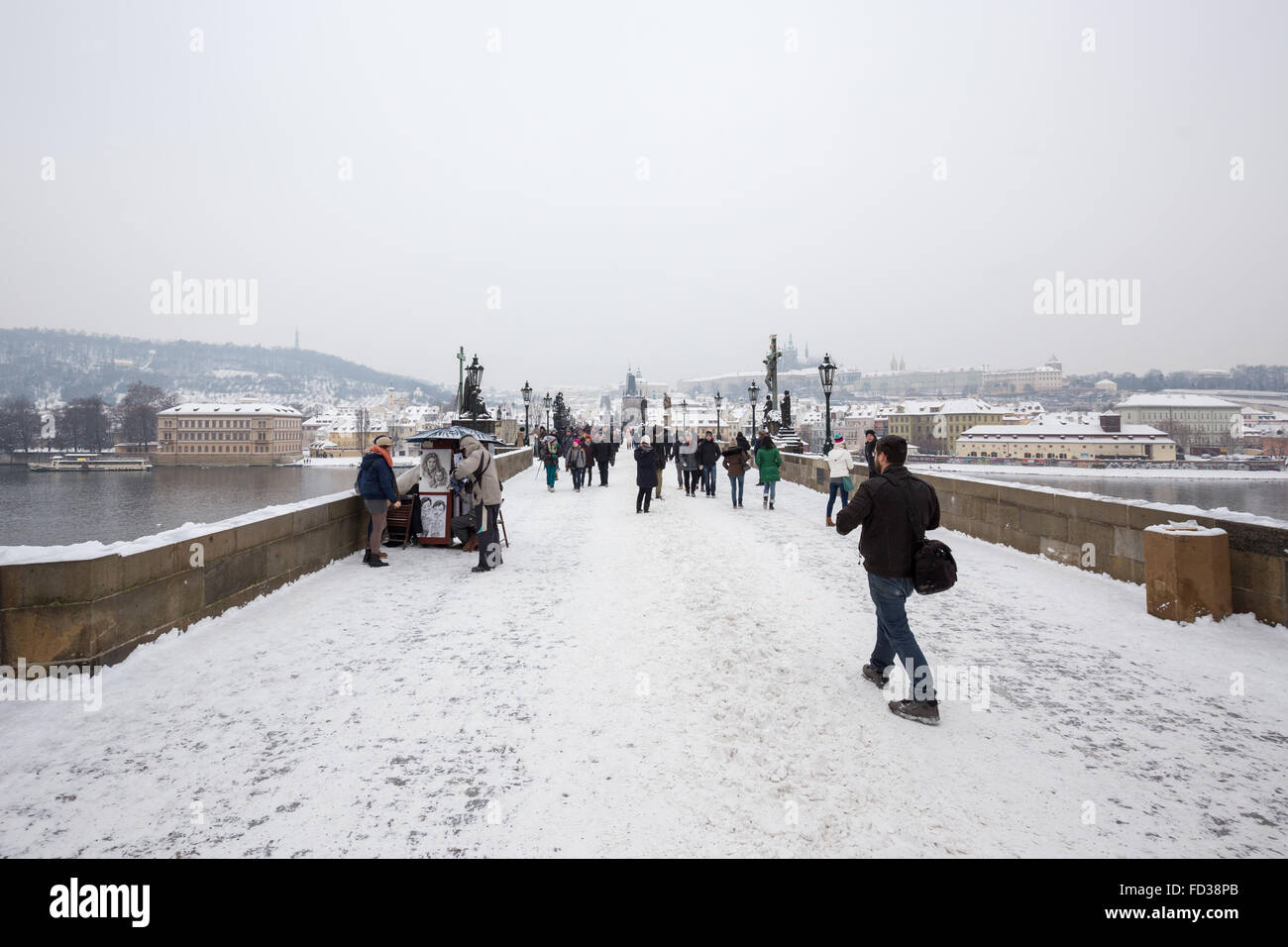 Tourists walking in the Charles bridge in winter, Prague, Czech republic Stock Photo