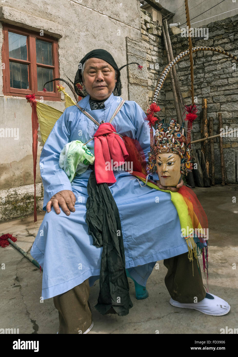 Unmasked Old Han Ground Opera performer resting in courtyard, Liuguan Old Han Village, Guizhou Province, China Stock Photo