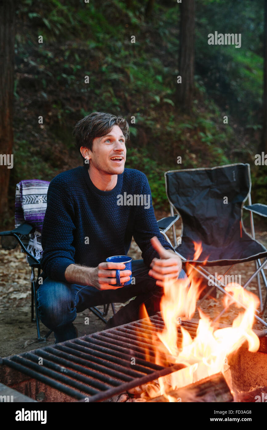 A young man sits around the campfire telling stories with friends in Big Sur, California. Stock Photo