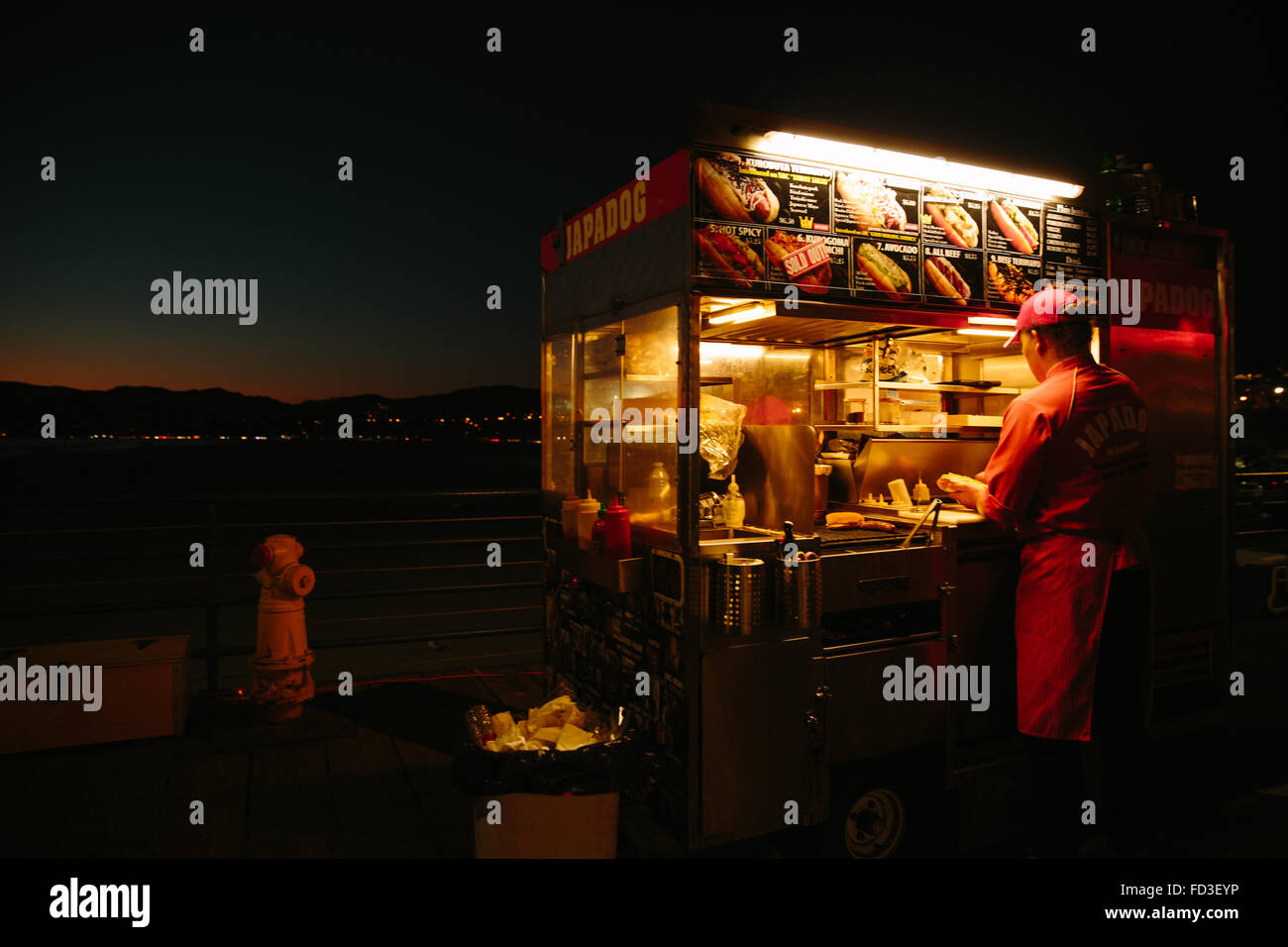 A food cart worker at Japadog on the historic Santa Monica pier. Santa Monica, California. Stock Photo