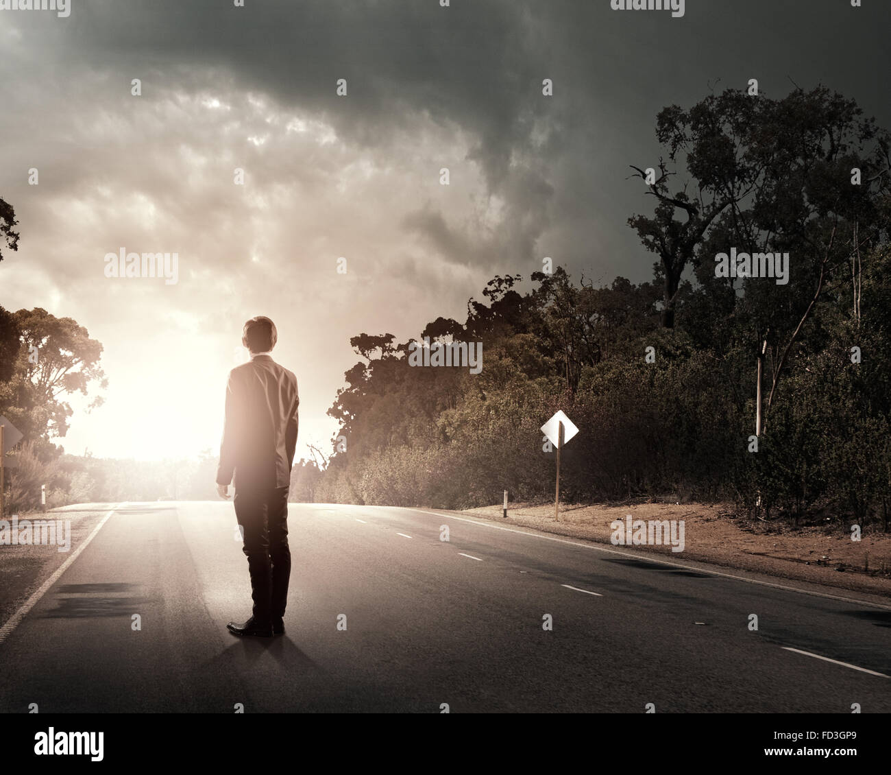 Back view of businessman standing on road and looking far away Stock ...