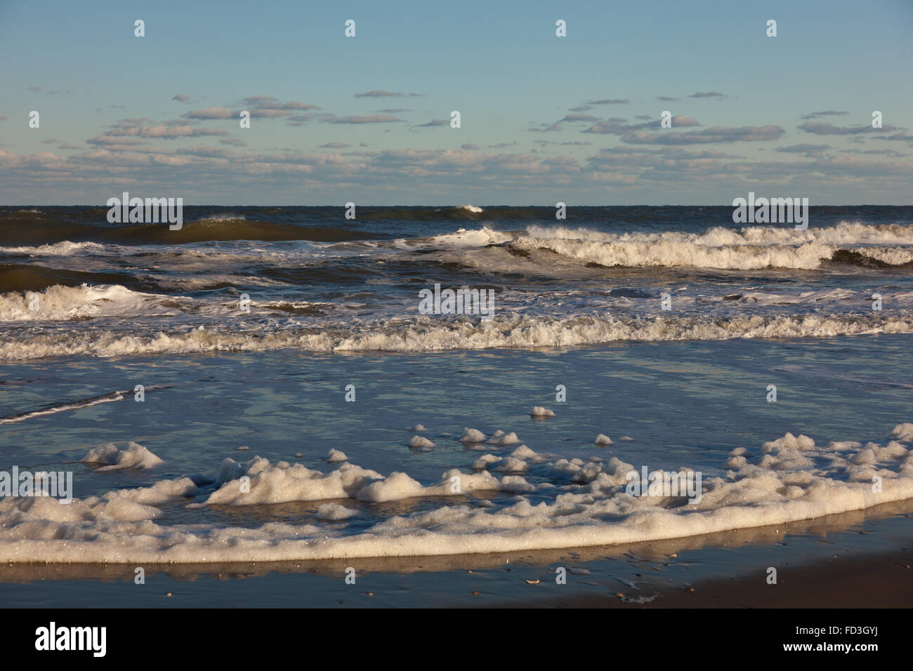 Waves and foam hitting the beach Stock Photo - Alamy