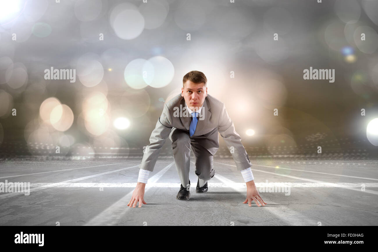 Young determined businessman standing in start position Stock Photo - Alamy