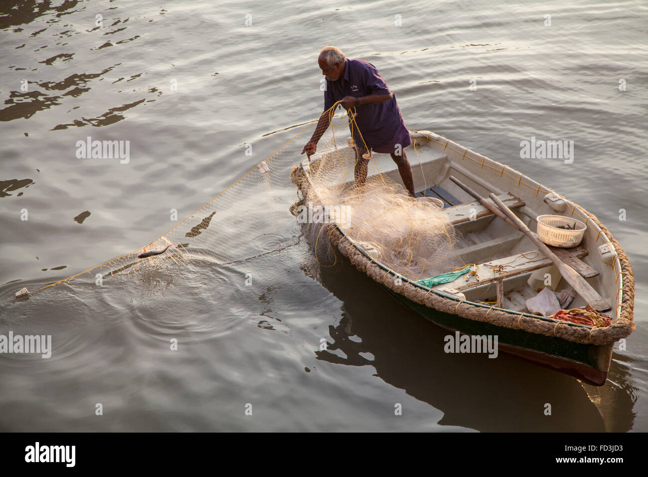 Fisherman pulling in his net in Mumbai (Bombay) Harbour. Stock Photo