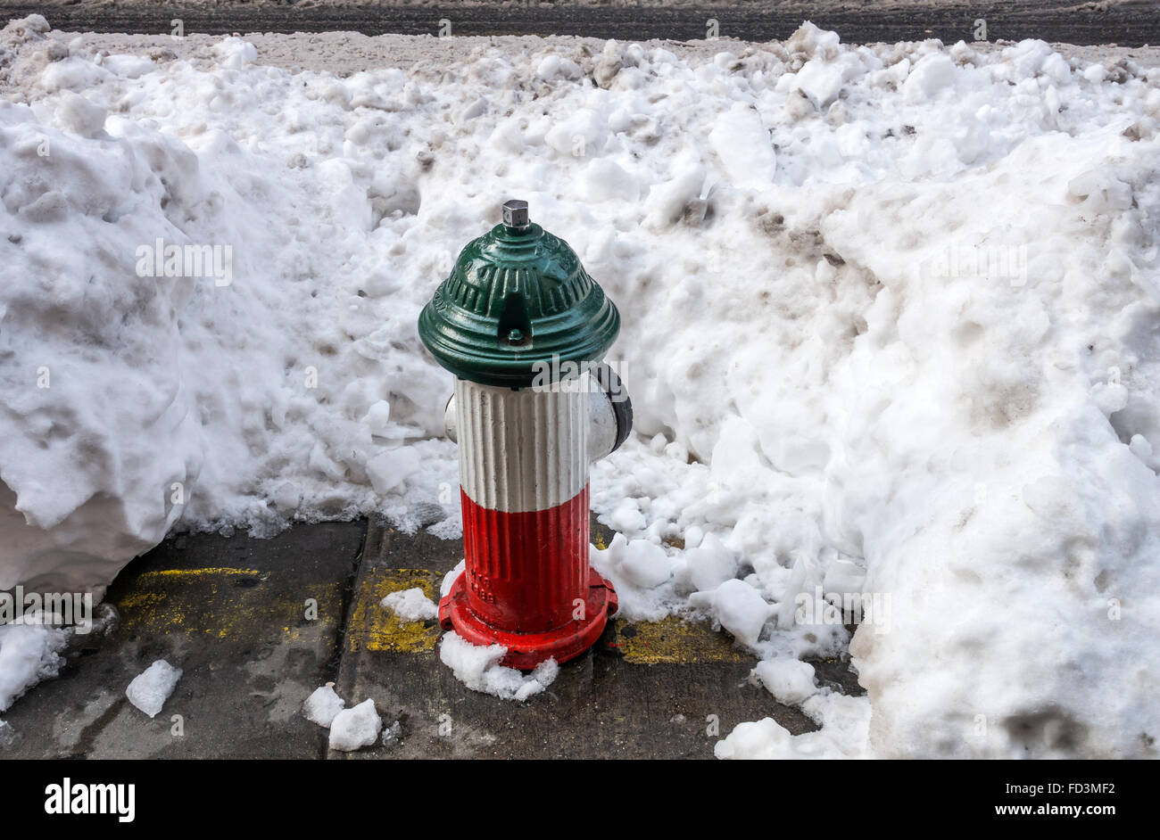 Red, white, and green fire hydrant after Jonas winter snow storm in Little Italy in New York City Stock Photo