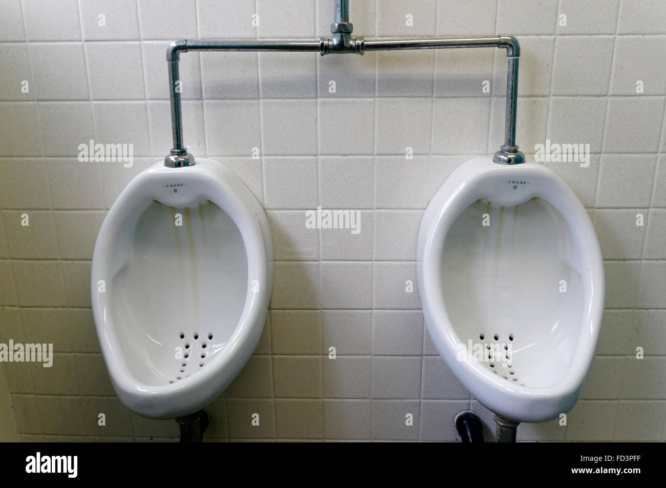 Pair of porcelain urinals in a public washroom Stock Photo