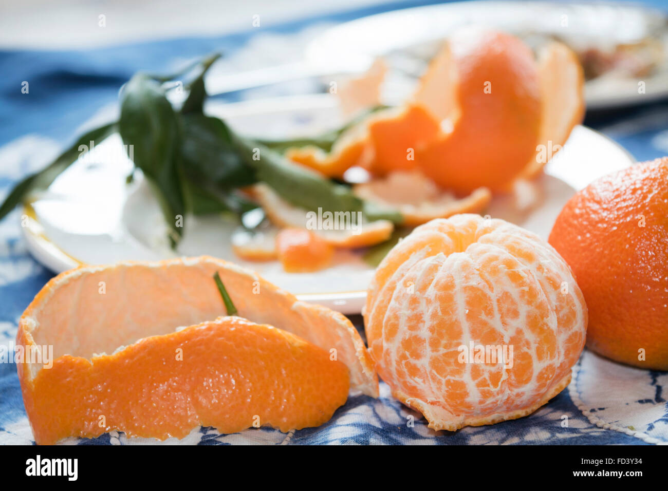 Two ripe clementines one peeled and one whole Stock Photo Alamy