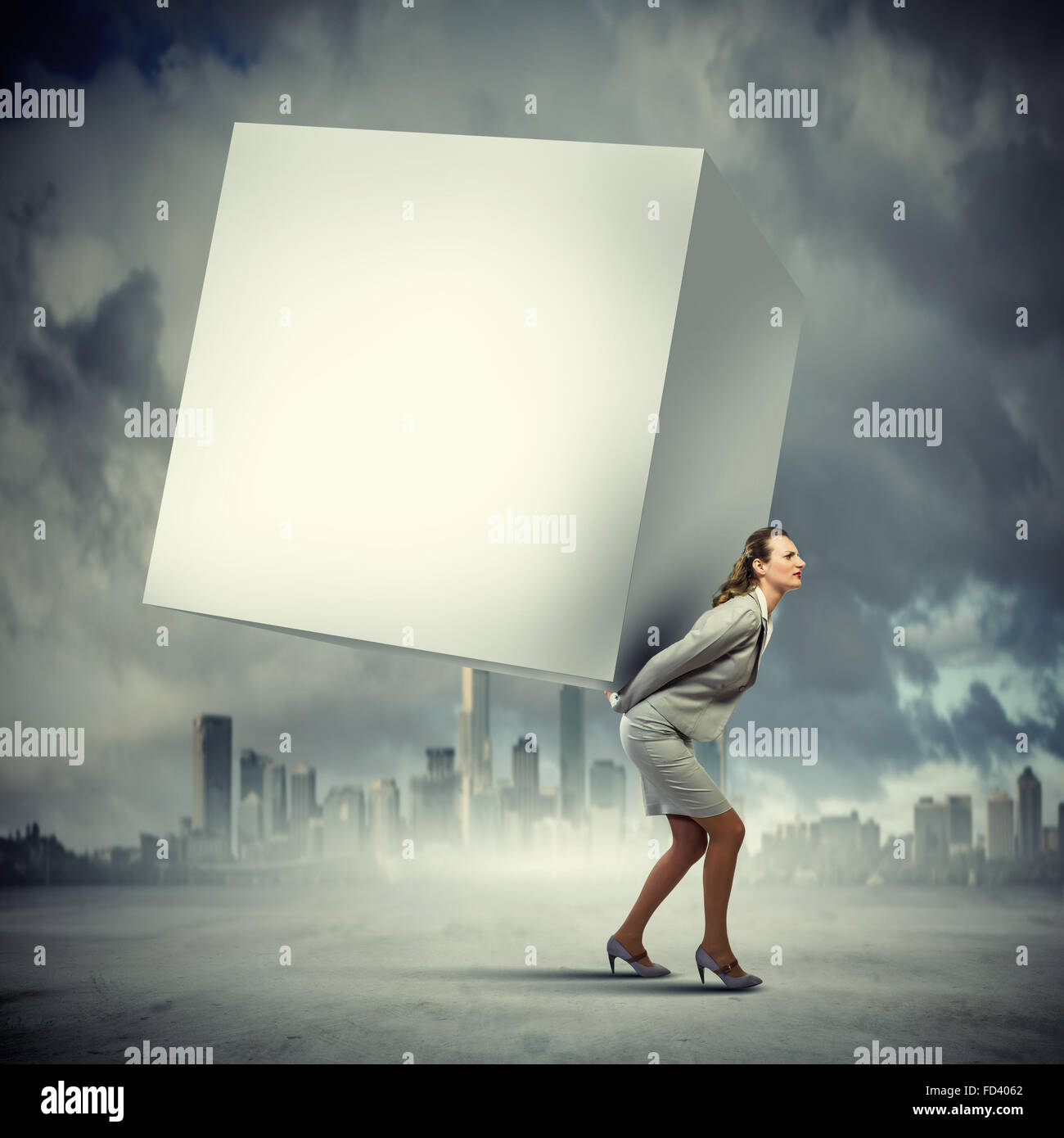 Image of businesswoman carrying big white cube on her back. Place for text Stock Photo