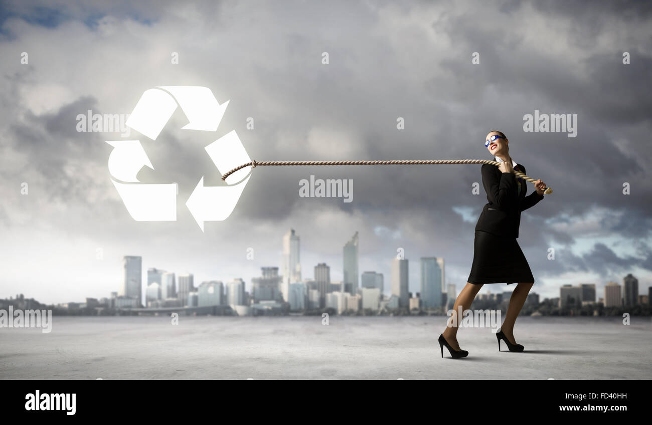 Image of businesswoman in goggles pulling recycle sign with rope Stock