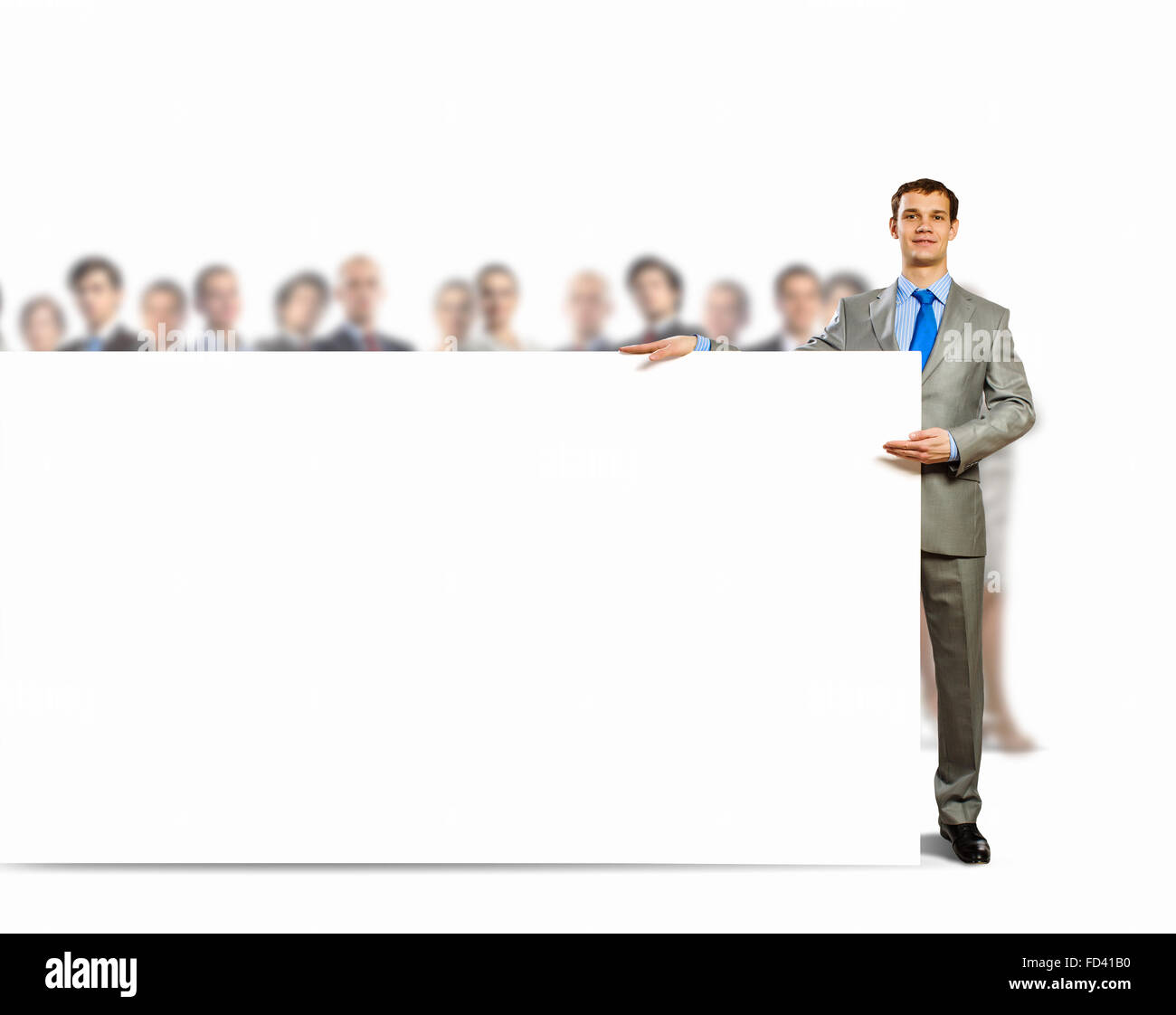 Image of young man holding blank banner with crowd of business people ...