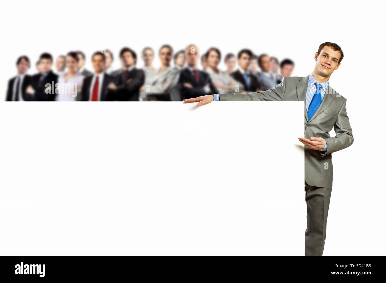 Image of young man holding blank banner with crowd of business people ...