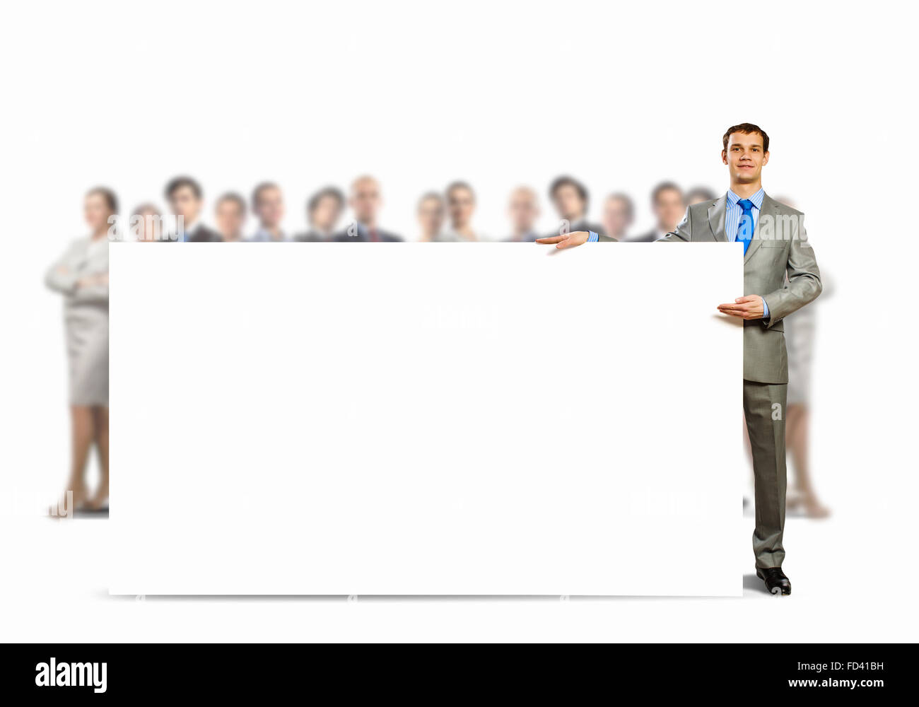 Image of young man holding blank banner with crowd of business people ...