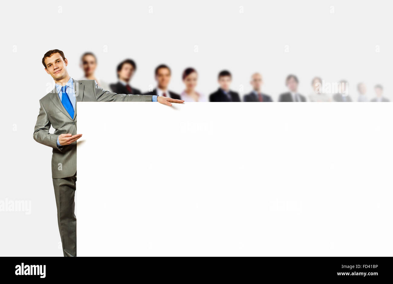 Image of young man holding blank banner with crowd of business people ...