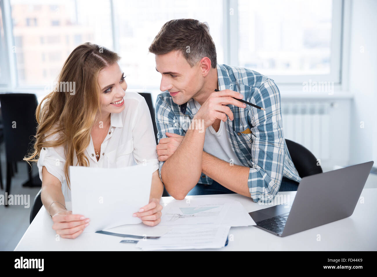 Cheerful man and woman working and flirting on business meeting Stock Photo