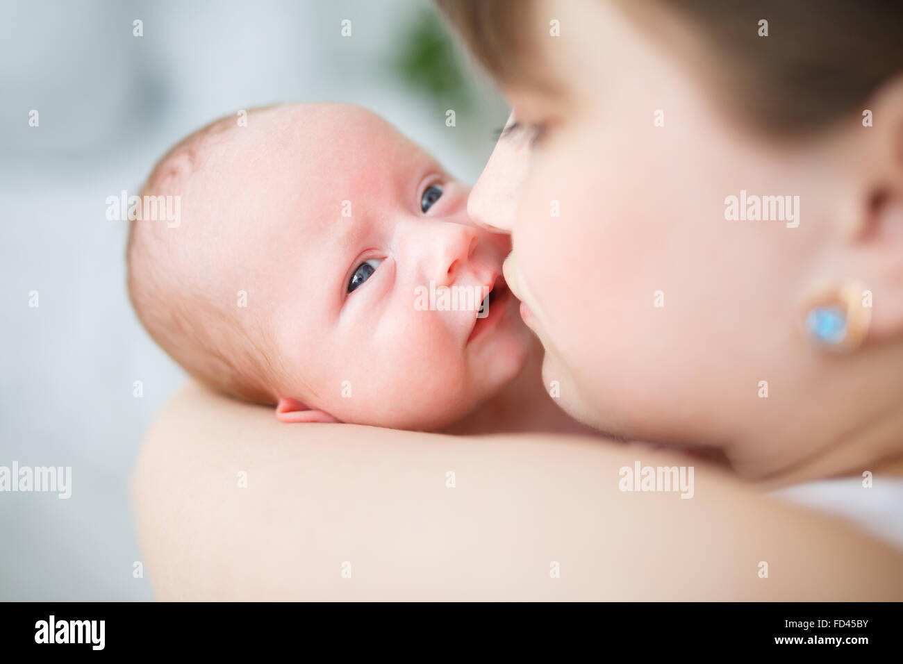 Mother holding her one month old son in studio Stock Photo