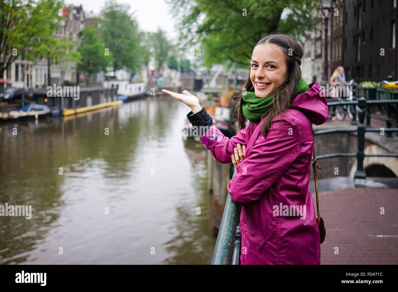 the beautiful young woman wearing a purple rain jacket shows us the