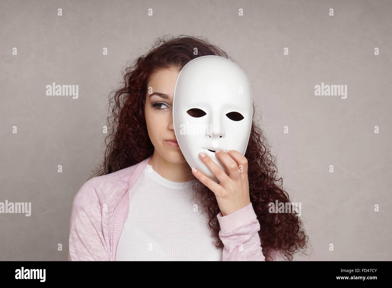 sad girl hiding behind mask Stock Photo Alamy