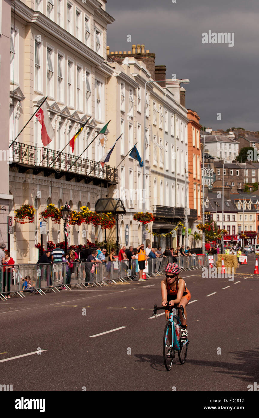 Female triathlete starts the bike section under a dramatic sky  in Cobh Triathlon, Cobh, County Cork, Ireland. Stock Photo