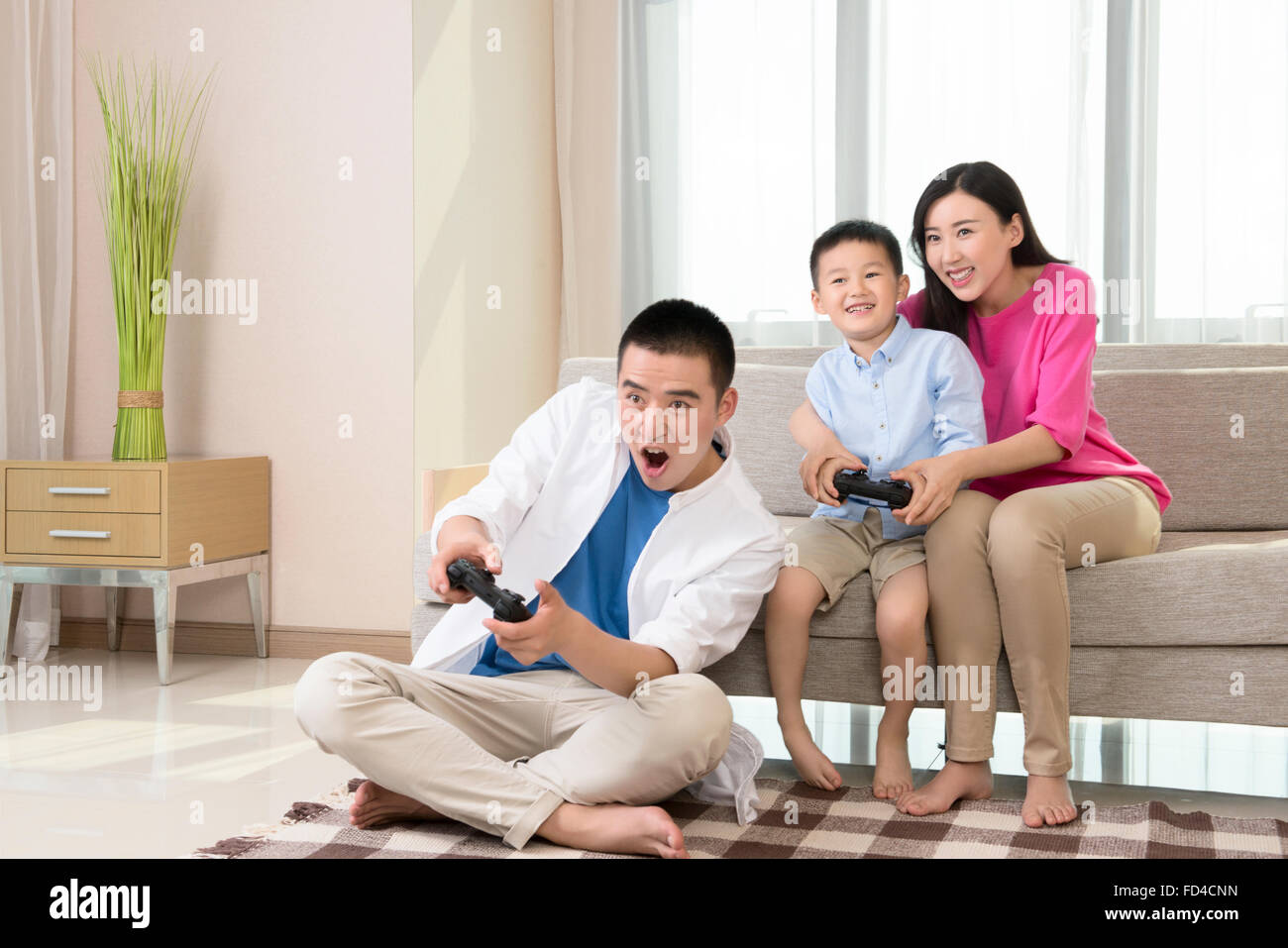 Young family playing video game Stock Photo