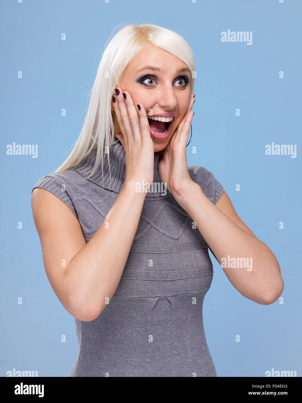 Closeup portrait of surprised young lady on blue background Stock Photo ...