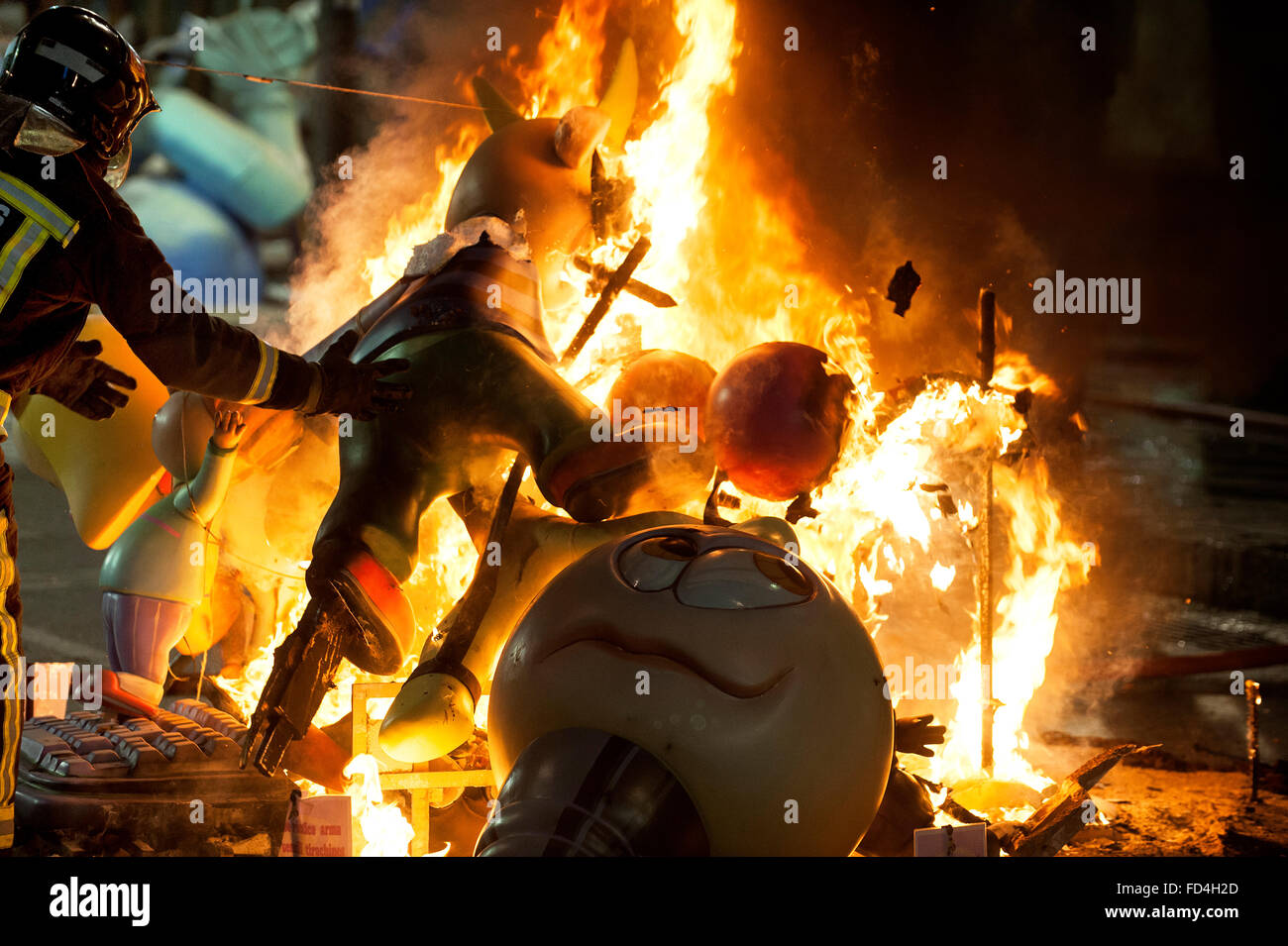 A firefighter watches that nothing happens while the fire burns. Stock Photo