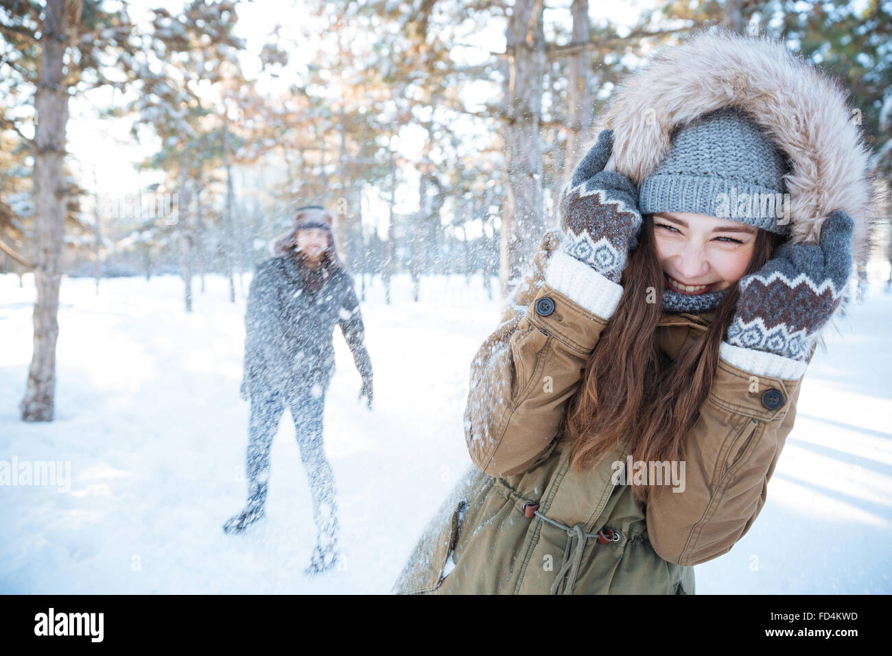 Happy young couple in winter clothes playing snowballs outdoors Stock ...