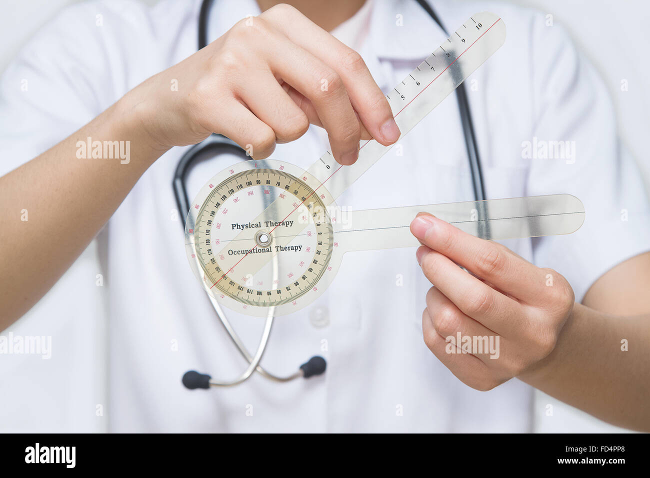 physiotherapist holding a goniometer for measuring range of motion Stock Photo