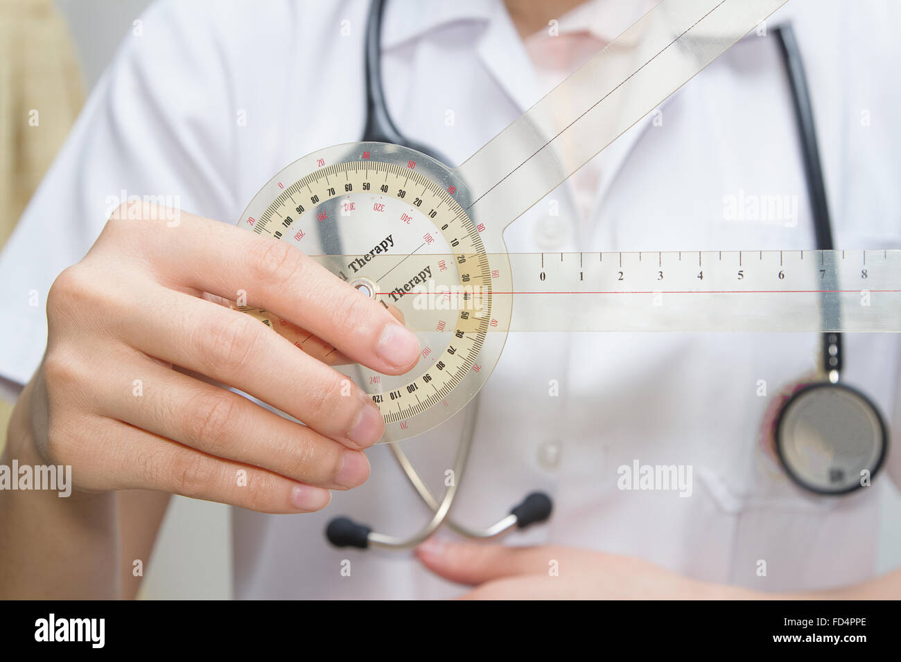 physiotherapist holding a goniometer for measuring range of motion Stock Photo