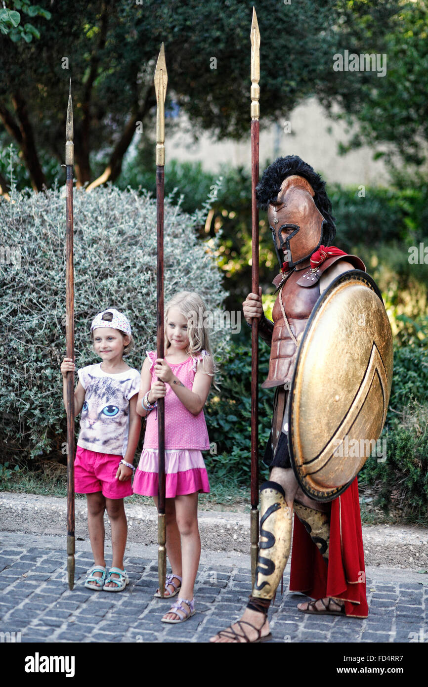 Two girls with an ancient Greek warrior in the streets of Athens, Greece Stock Photo
