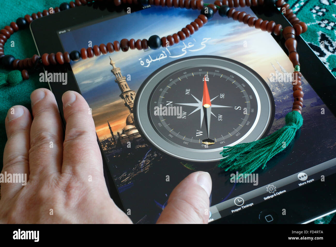 Islamic compass on an Ipad. Qibla compass used by Muslims to indicate the direction of Mecca. Stock Photo