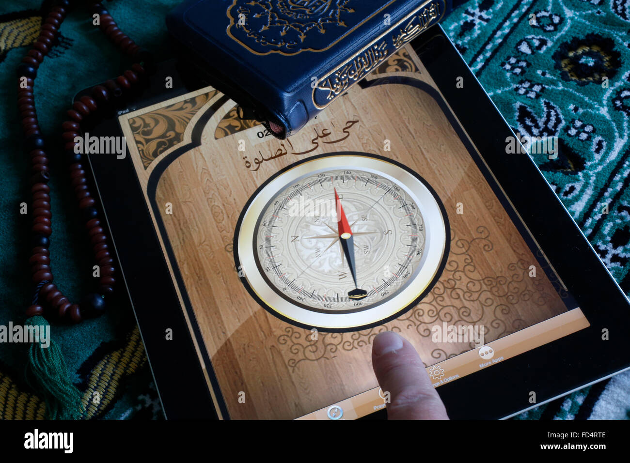 Islamic compass on an Ipad. Qibla compass used by Muslims to indicate the direction of Mecca. Stock Photo