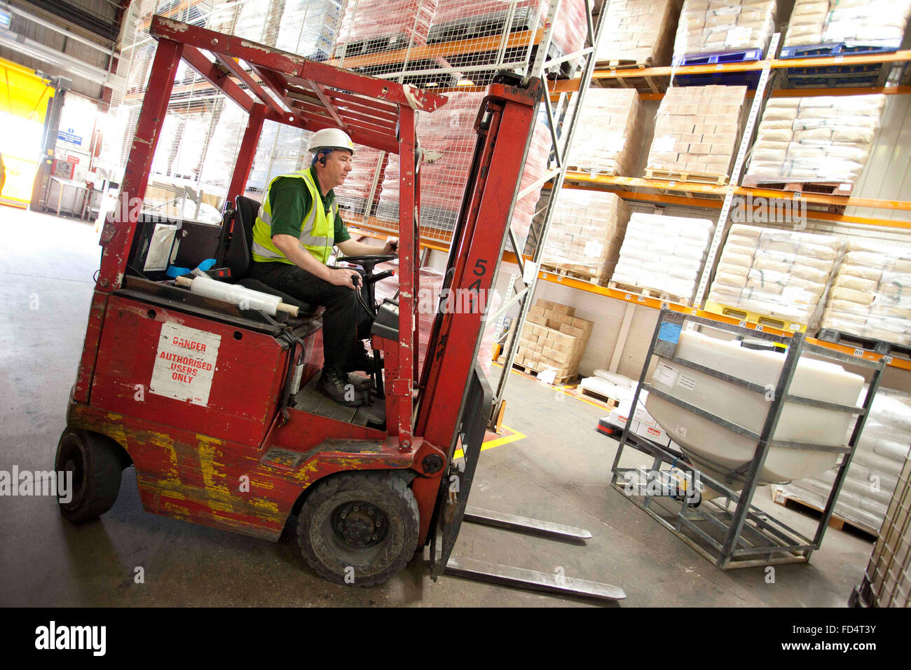 a man working on a fork lift truck in a warehouse Stock Photo Alamy