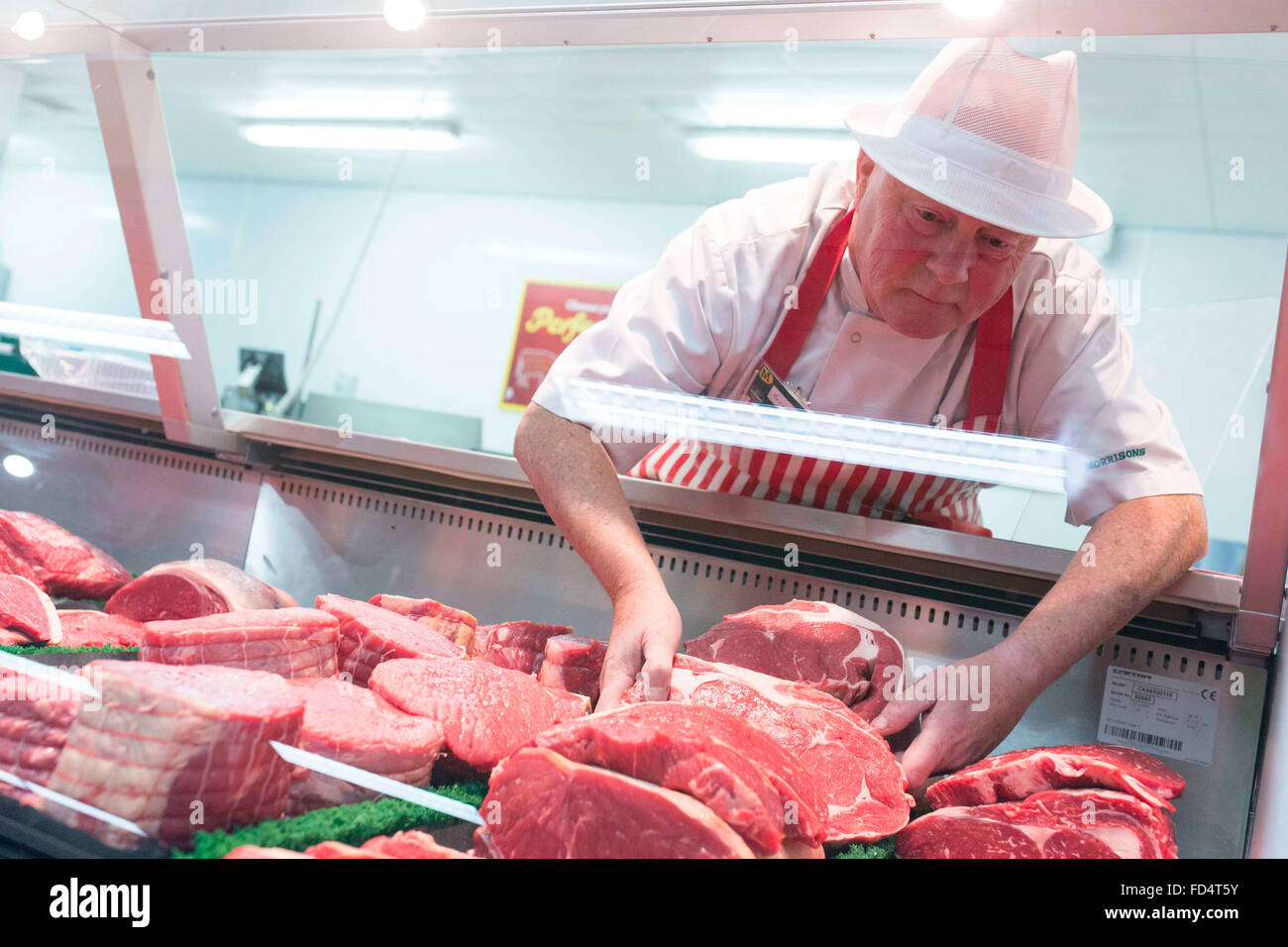 Morrisons supermarket. A man works on the butcher counter Stock Photo
