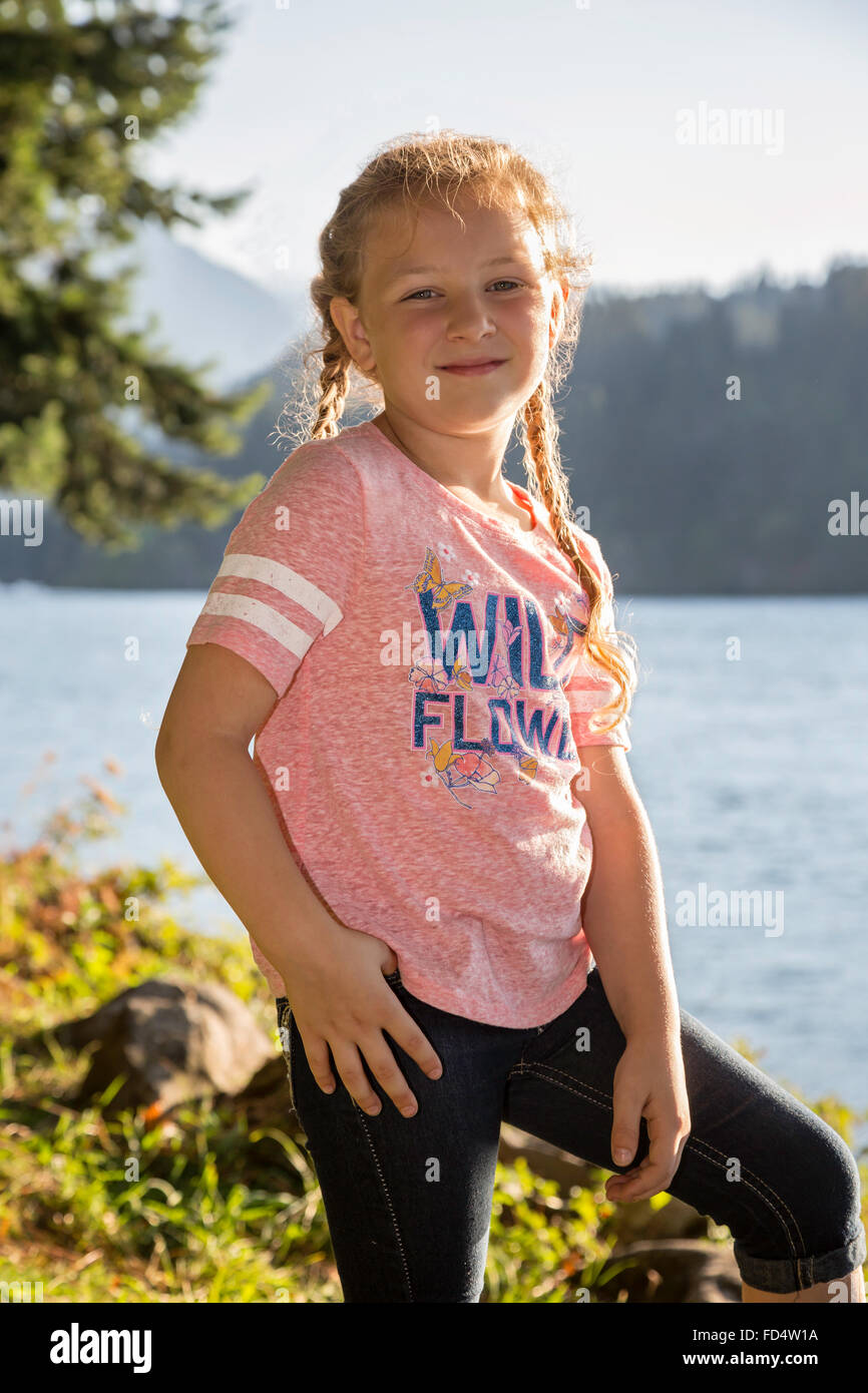 Happy young girl posing outdoors at a park near the river Stock Photo