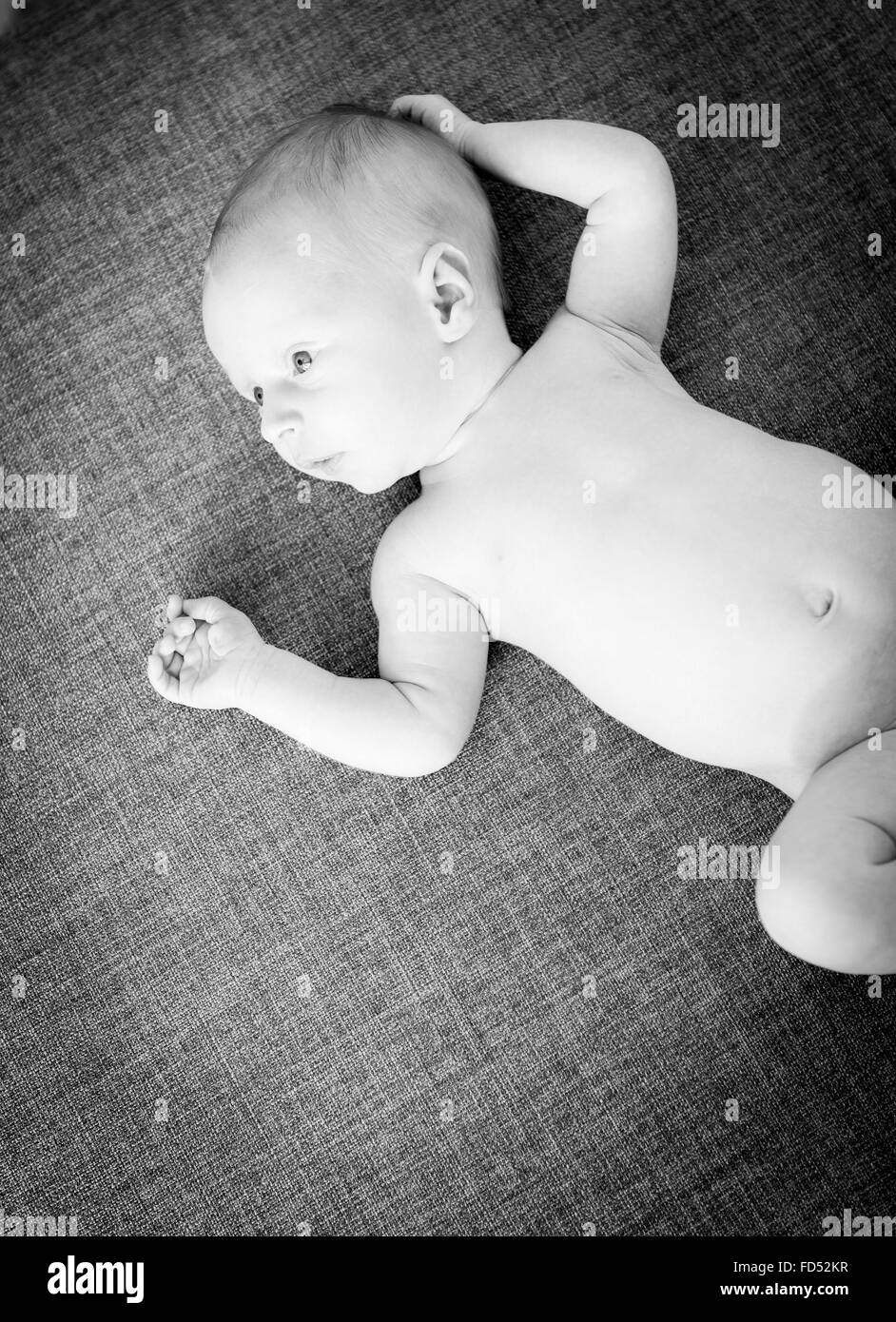 Baby boy only weeks old stares with wide eyes in stunning black and white Stock Photo