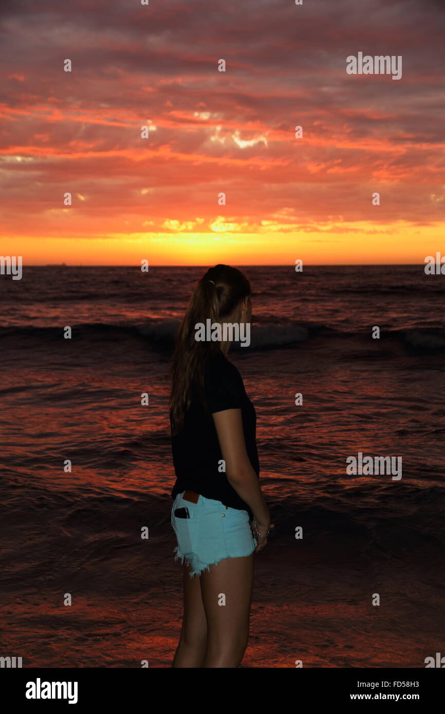 Girl on beach watching the sunset Stock Photo - Alamy
